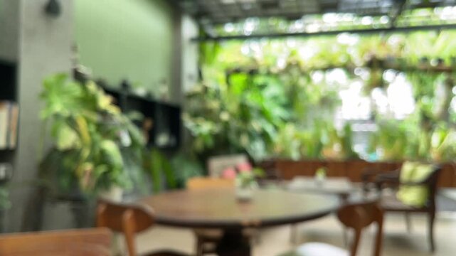 Exterior of cafe, coffe shop or restaurant with plants, tables and chairs. empty. green leaves, leaf. nature. eco, ecology. environment. plant. cozy. outdoor. indoor. interior. blur, blurry, blurred. 