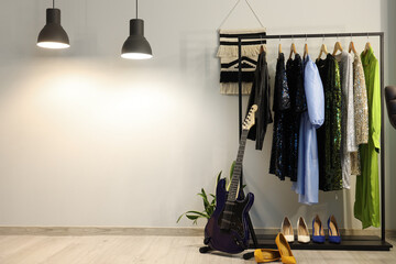 Interior of dressing room with guitar, clothes rack and glowing lamps