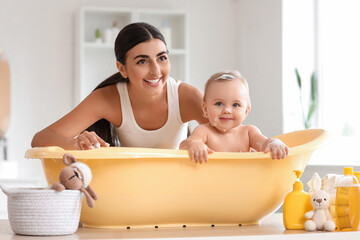 Young mother bathing her baby at home