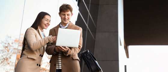 Young couple using laptop near airport