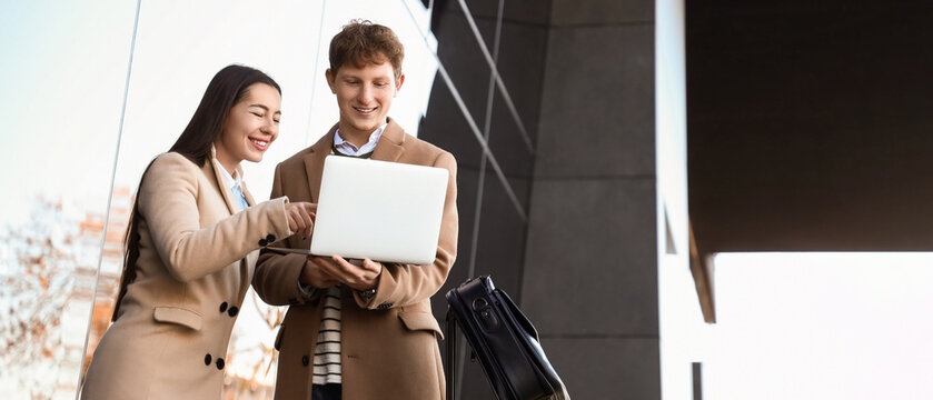 Young couple using laptop near airport