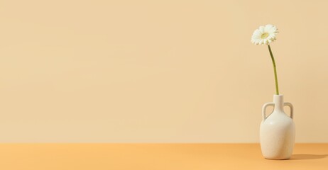 Obraz premium Vase with gerbera flower on beige background with space for text