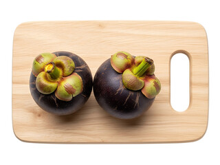 Top view two mangosteen fruits on a cutting board, white background isolated