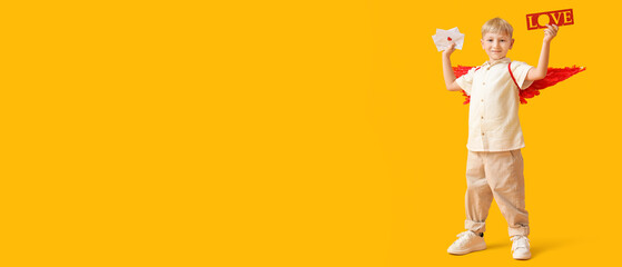 Cute little happy boy dressed as cupid with letters and word LOVE on yellow background. Valentine's...