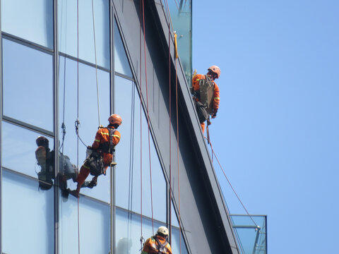 Window cleaners suspended by ropes on high-rise building in Yangon, Myanmar