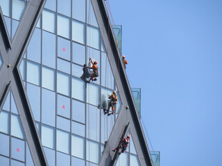 Window cleaners suspended by ropes on high-rise building in Yangon, Myanmar