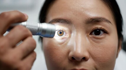 Asian woman undergoing eye examination with medical device. - Powered by Adobe