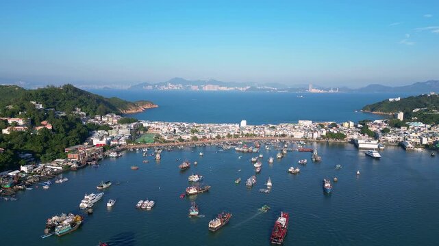 Cheung Chau, Hongkong: forward aerial drone footage of Cheung Chau, a fisherman village in a typical Hong Kong outlying island, with Lantau mountain in the background