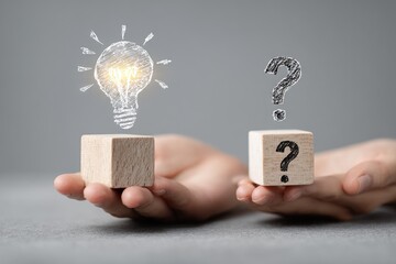 Human hands holding wooden blocks, one with a question mark and the other with a lightbulb