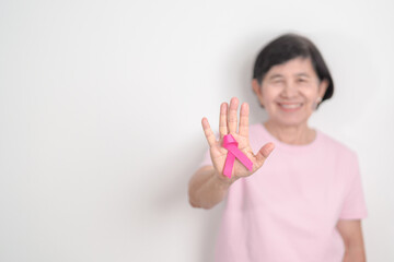 Elderly woman with pink Ribbon for Pink October Breast Cancer Awareness month, May Women Health, February World cancer day, support people life and illness. National cancer survivors month
