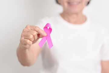 Elderly woman with pink Ribbon for Pink October Breast Cancer Awareness month, May Women Health, February World cancer day, support people life and illness. National cancer survivors month