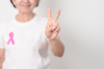 Elderly woman with pink Ribbon for Pink October Breast Cancer Awareness month, May Women Health, February World cancer day, support people life and illness. National cancer survivors month