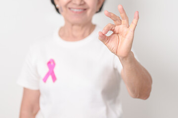 Elderly woman with pink Ribbon for Pink October Breast Cancer Awareness month, May Women Health, February World cancer day, support people life and illness. National cancer survivors month