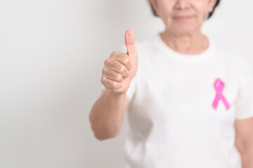 Elderly woman with pink Ribbon for Pink October Breast Cancer Awareness month, May Women Health, February World cancer day, support people life and illness. National cancer survivors month