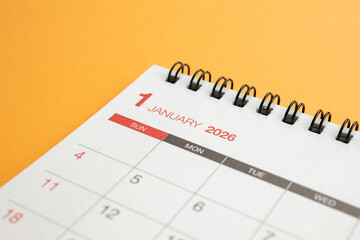 Close up of January 2026 desk calendar page on vibrant orange background for business planning and new year goals