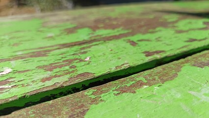 Weathered Wooden Texture: A close-up shot revealing a worn, wooden surface with flaking green paint, displaying a unique, aged aesthetic and texture.