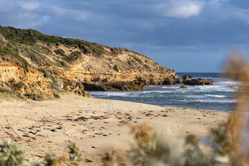 Sorrento Ocean Beach in Victoria, Australia, featuring sandy shoreline, rugged cliffs, rolling ocean waves, and native coastal vegetation