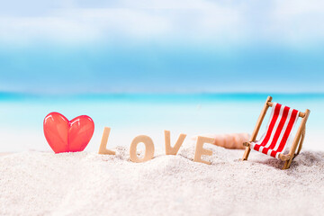 love wooden text on white sand beach with tropical blue sea and clear blue sky