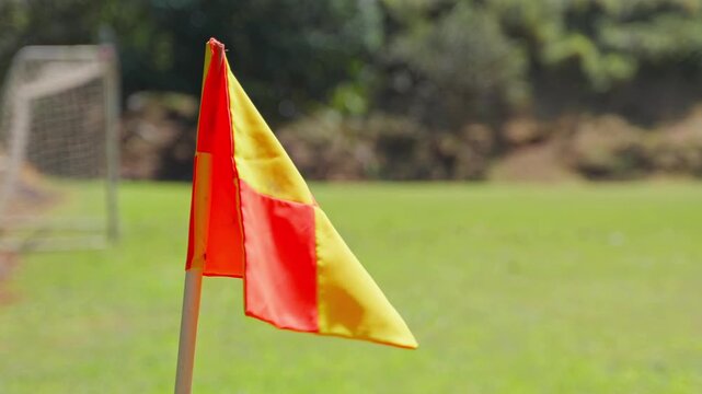 Soccer corner flag waving on a sports field during a sunny day