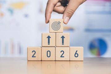 A wooden block with the symbol 2026, representing growth in investment, 2026 text on wooden block with icons. Goals.