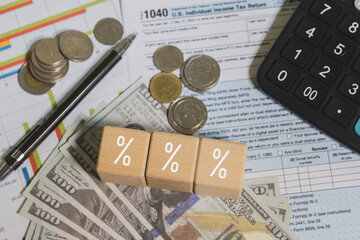 Wooden blocks with the word tax. Calculator on phone. Interest, Financial calculations, Tax law, Tax payment. Tax planning concept for 2026.