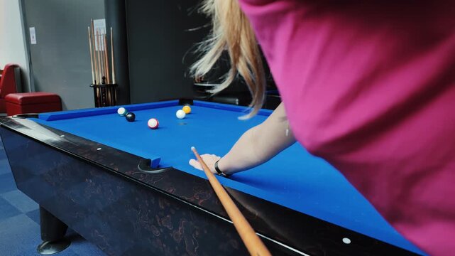 Slow Motion Scene Of Woman In Pink Shirt Taking Precise Pool Shot In Bright Room