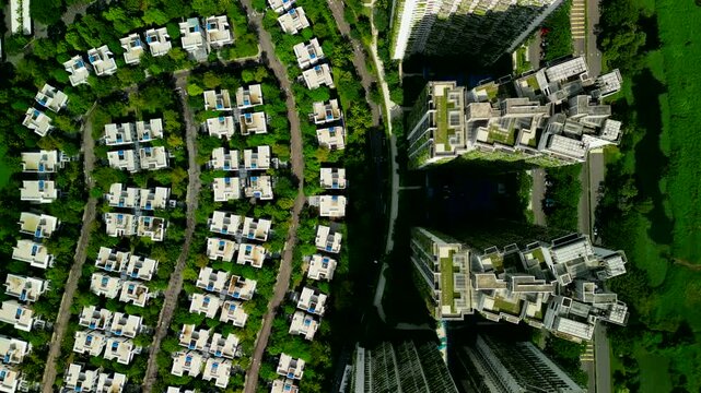 Aerial drone top down view of high density residential towers and low rise villas arranged in a green urban layout in forest city, johor, malaysia