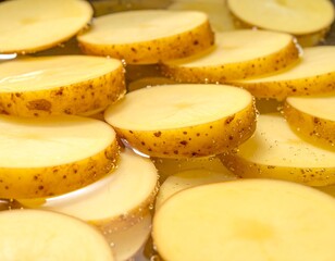 Sliced, golden-hued root vegetable rounds sit submerged in a translucent liquid, their textures and natural colors highlighted