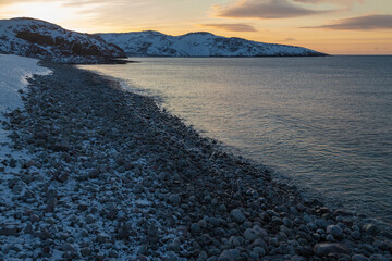 View of the Dragon Egg Beach (Round Stones Beach) on a March evening. The outskirts of the village of Teriberka. Murmansk region, Russia