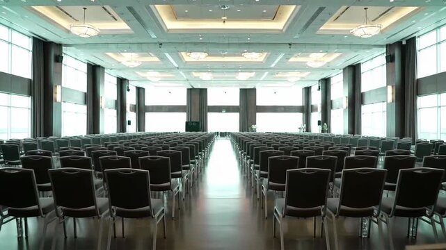 Rows of chairs in a large conference hall, ready for an event.