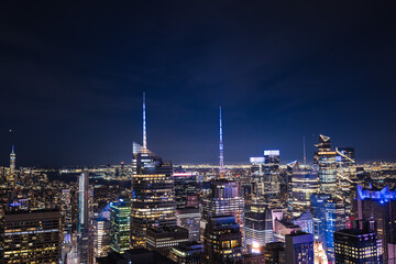 Obraz premium Night cityscape of Midtown Manhattan with illuminated skyscrapers and bright skyline lights