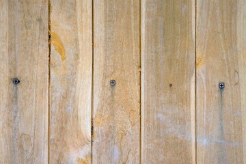 Vertical wooden planks with visible nails and natural grain, rustic weathered wood texture background suitable for construction, design, or vintage concepts.