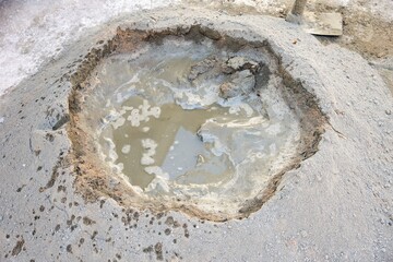 Pile of wet cement mixed with sand and water prepared by construction workers for plastering, showing fresh mortar texture and building material detail.