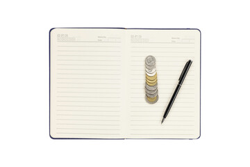 Open notebook with stacked coins and pen isolated on white background with clipping path.