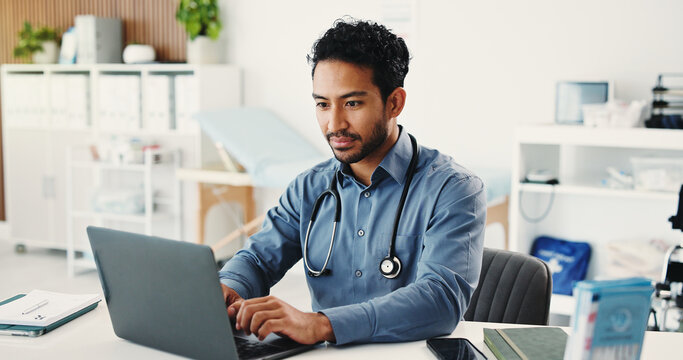 Man, doctor and reading with laptop in hospital for research, medical report and confirm surgery. Male person, pc and schedule appointment for Telehealth, healthcare results and treatment information