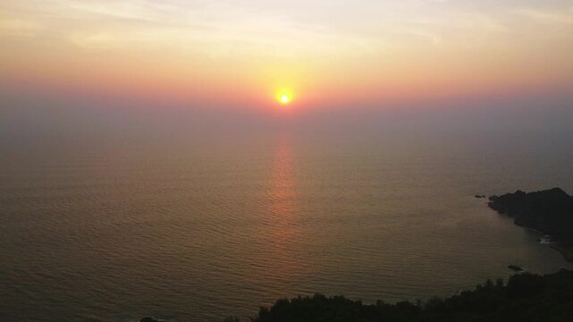 Beautiful sunset over the Arabian Sea, with the sun dipping below the horizon and warm golden light spreading across calm waters.