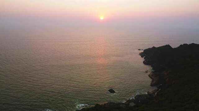Beautiful sunset over the Arabian Sea, with the sun dipping below the horizon and warm golden light spreading across calm waters.