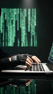 Dark Hooded Figure Engaged in Hacking with Computer in Low Light Environment