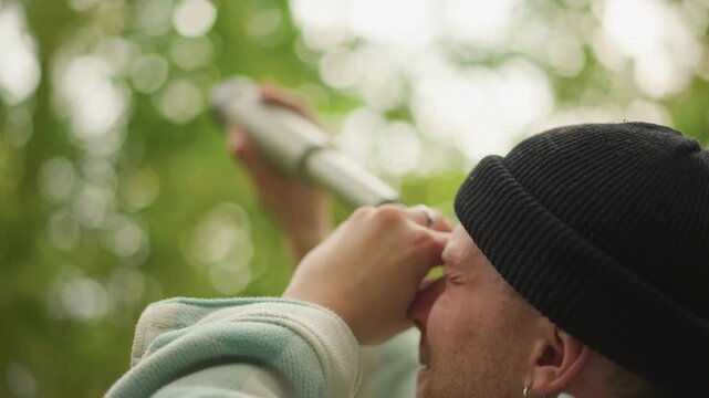 scout aims monocular at green canopy, focused observer in beanie concentrates on treetop, careful search for birds and distant movement, soft bokeh background and calm morning light