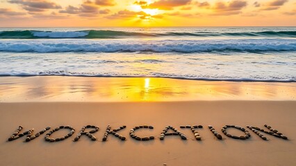 Workcation spelled with stones on a sandy beach at sunset with ocean waves