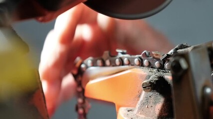 A detailed macro slow-motion shot captures intense sparks flying as an electric grinder sharpens a chainsaw chain. Ideal for forestry equipment ads, tool maintenance guides, and industrial marketing.