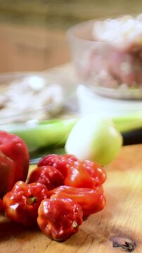 Vertical close up of red hot chillies, Venezuelan aj&iacute; peppers on a cutting board in a kitchen, fresh, vibrant, traditional Latin American ingredients.