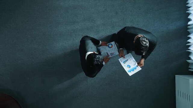 Top down aerial view of professional business man sharing idea while give document to marketing team. Skilled manager looking at financial statistic while calling phone at meeting room. Directorate.