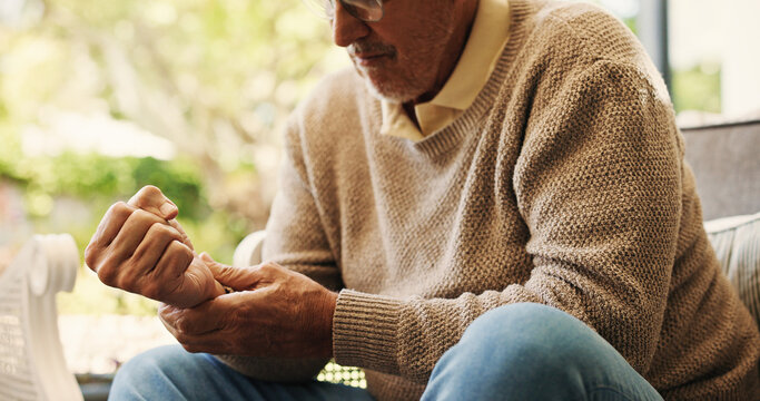 Hands, sofa and wrist pain in home, injury and senior man in lounge with joint inflammation. Elderly person, frustrated and muscle fatigue for carpal tunnel, tendinitis or stress for strain at house