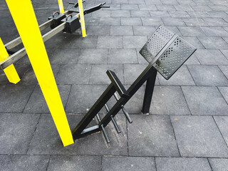 Outdoor gym equipment on a paved surface in a public park.