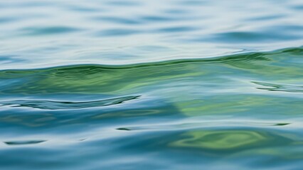 Calming ocean waves with green reflections on surface water
