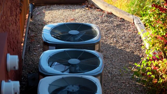 Home HVAC Air Conditioner system outside the house. Bright autumn sunny day with beautiful foliage. Bushes leaves moving on the wind