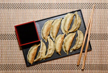 Tray of gyoza with soy sauce and chopsticks