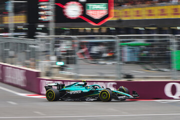 Fototapeta premium BAKU, AZERBAIJAN - SEPTEMBER 21, 2025: Two-time World Champion Fernando Alonso maneuvers the Aston Martin Aramco AMR25 through the streets of Baku during the Formula 1 Azerbaijan Grand Prix