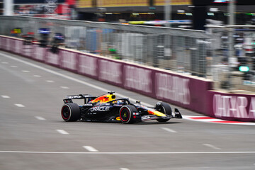 Naklejka premium BAKU, AZERBAIJAN - SEPTEMBER 21, 2025: Sergio Perez in the Oracle Red Bull Racing RB21 leads a pack of Formula 1 cars down a straight at the Baku City Circuit during the Azerbaijan Grand Prix